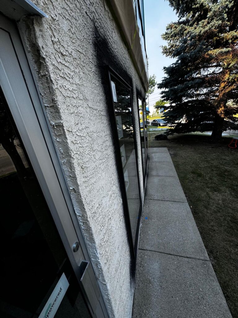 exterior stucco siding painting in progress in Calgary, AB, wall view