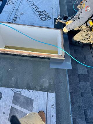 proprietary velux flashing being installed to a skylight by a roofer on their knees